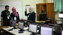 Sejumlah Guru mempersiapkan komputer untuk ujian nasional (UN) di SMA 70, Jakarta, Senin (13/4/2015). Sebanyak 585 dari 70 ribu sekolah menjadi percontohan menjalankan ujian nasional berbasis komputer di seluruh Indonesia.  (Liputan6.com/Faizal Fanani)