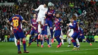 Bek Real Madrid Raphael Varane (kiri tengah) dan pemain Barcelona, Gerard Pique melompat saat berebut bola pada lanjutan pertandingan La Liga di Santiago Bernabeu, Minggu (2/3/2020).  Real Madrid membungkam Barcelona 2-0 dan merebut puncak klasemen dari Barcelona . (AP/Manu Fernandez)