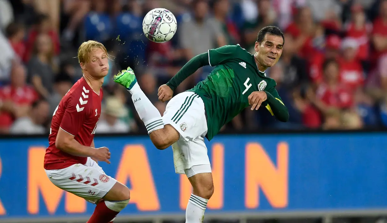 Bek Meksiko, Rafael Marquez (kanan) mengontrol bola dari kejaran pemain Denmark Kasper Dolberg di laga persahabatan di Brondby (9/6). Mantan pemain Barcelona ini kini berusia 39 tahun dan akan berlaga di Piala Dunia 2018. (AFP Photo/Ritzau Scanpix)
