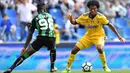 Pemain Sassuolo, Claud Adjapong (kiri) mencoba merebut bola dari pemain Juventus, Juan Cuadrado pada lanjutan Serie A di  Stadio Citta del Tricolore, Reggio Emilia, Italia (17/9/2017). Juventus menang 3-1. (AFP/Marco Bertorello)