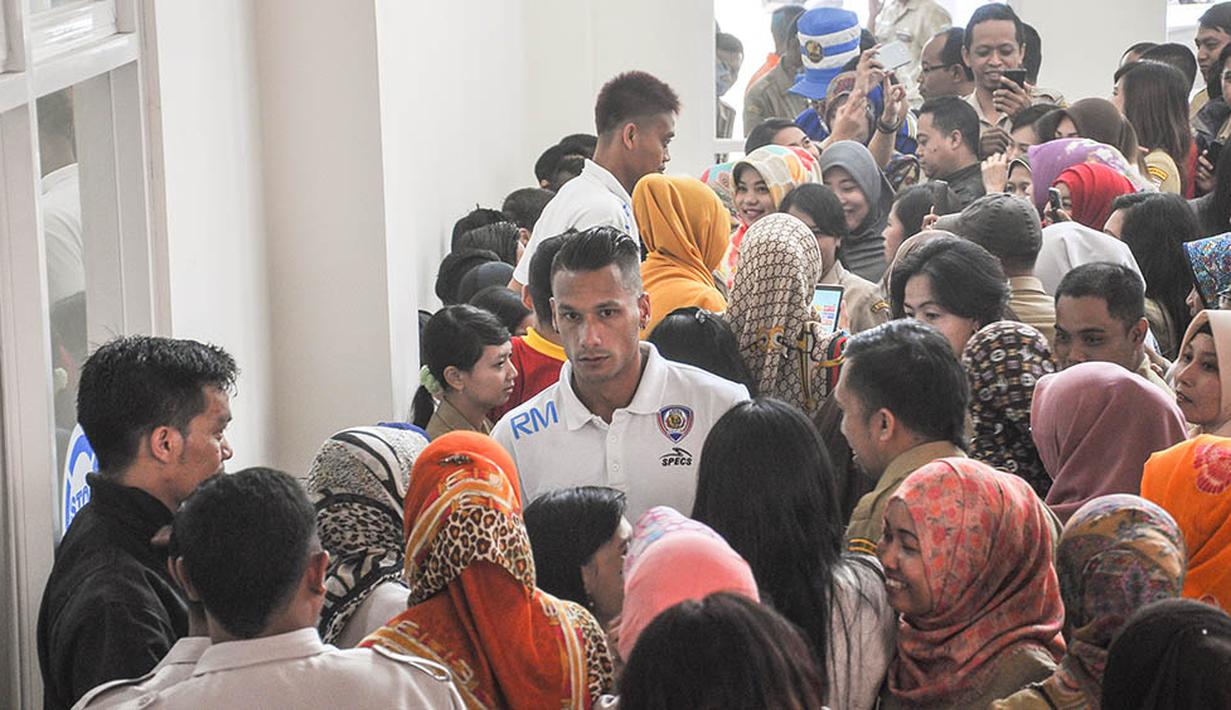 Gelandang Arema Cronus, Raphael Maitimo, diserbu pegawai Pemerintah Kota Batu yang mengajaknya untuk selfie. (Bola.com/Iwan Setiawan)