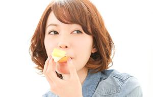 Seorang wanita Asia yang cantik sedang menikmati camilan.