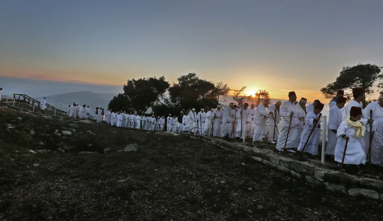 Kaum Samaritan berjalan menuju puncak Gunung Gerizim untuk melakukan doa dalam perayaan hari Sukkot di Israel (4/10). (AFP Photo/Jaafar Ashtiyeh)