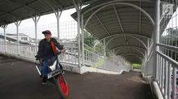 Pengendara motor memanfaatkan JPO (jembatan penyeberangan orang) di kawasan Pasar Minggu, Jakarta, Selasa (17/10). Aksi tidak tertib tersebut mengganggu hak pejalan kaki dan berpotensi membahayakan pengguna JPO. (Liputan6.com/Immanuel Antonius)