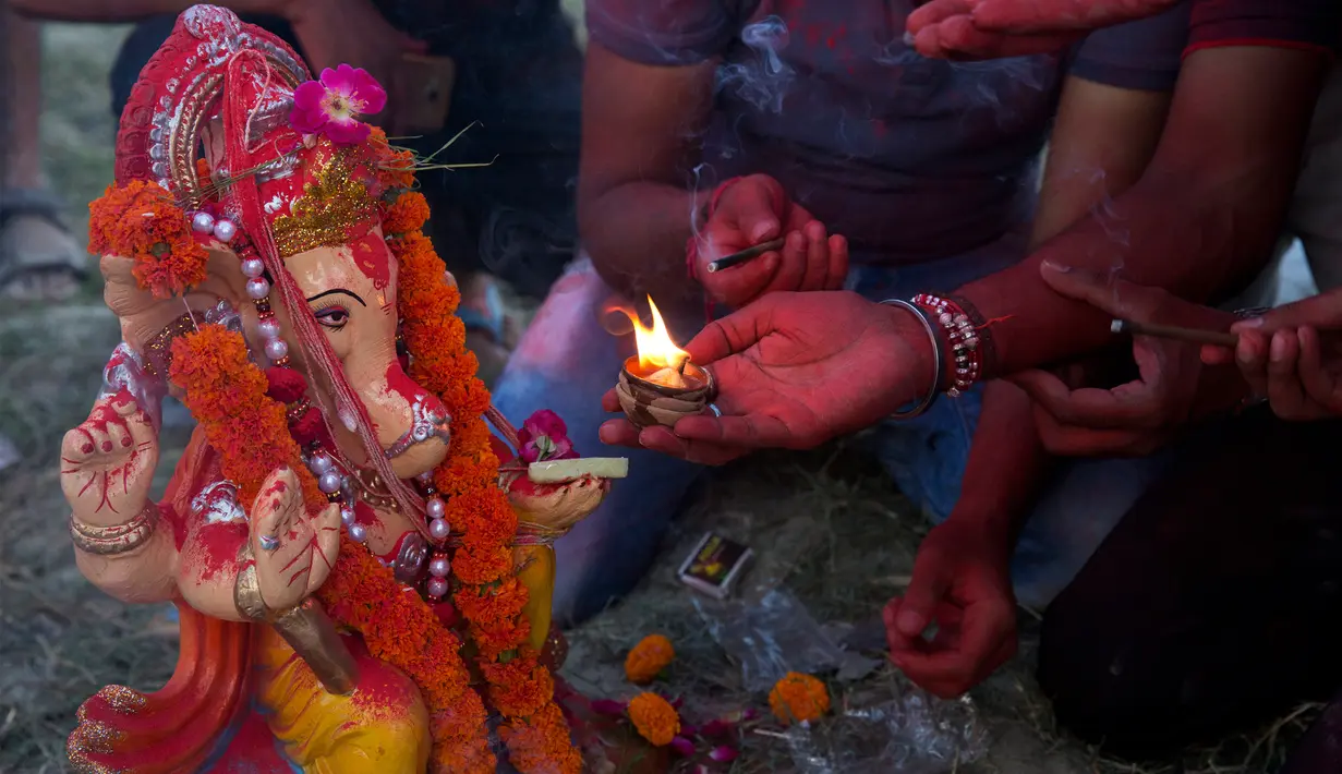 Umat Hindu India berdoa sebelum membenamkan patung Dewa Ganesha di kolam sementara dekat sungai Gangga, Allahabad, India, Selasa (5/9). Patung berkepala gajah ini merupakan anak dari Dewa Shiva dan Dewi Parvati. (Rajesh Kumar Singh/AP) 
