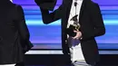 Personel Twenty One Pilots memperlihatkan celana panjangnya yang dilepas sesaat sebelum naik panggung menerima penghargaan Best Pop Duo/Group Performance pada ajang Grammy Awards 2017, Los Angeles, Minggu (12/2). (Kevin Winter/Getty Images for NARAS/AFP)