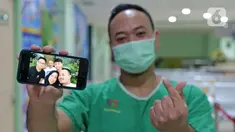Petugas analis laboratorium Yosaphat Dimaz (28) menunjukkan foto keluarga saat di RSUD Pasar Minggu, Jakarta, Jumat (22/5/2020). Yosaphat Dimaz sudah 2,5 bulan tidak bertemu keluarga selama bertugas menjaga COVID-19 di RSUD Pasar Minggu. (Liputan6.com/Herman Zakharia)