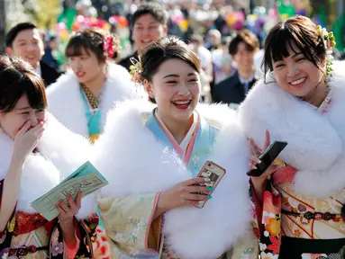 Tiga wanita berpakaian Kimono saat menghadiri upacara perayaan Coming of Age Day atau Hari Kedewasaan di Tokyo, Jepang  (14/1). Hari Kedewasaan jatuh di hari Senin minggu kedua di bulan Januari. (AP Photo/Koji Sasahara)
