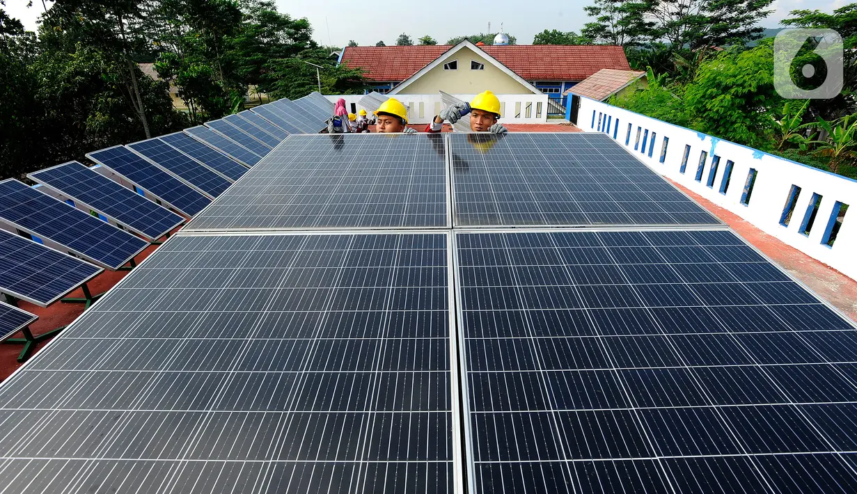 Seorang guru mengajarkan praktek perawatan solar panel kepada siswa kompetensi keahlian Teknik Energi Surya Hidro dan Angin (TESHA) di SMK Negeri 1 Kemang Bogor, Jawa Barat, Kamis (19/5/2022). Solar panel teserbut selain sebagai media pembelajaran siswa juga menghasilkan energi listrik yang digunakan untuk kebutuhan pasokan listrik di lab sekolah tersebut. (merdeka.com/Arie Basuki)