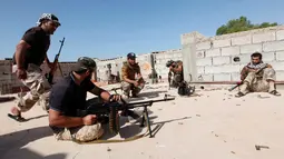 Pasukan militer pemerintah Libya mempersiapkan sejumlah senjata api saat melakukan serangan kepada para pejuang ISIS dari atap atap rumah di daerah Zaafran, di Sirte, Libya, 30 Juni 2016. (REUTERS/Ismail Zitouni)