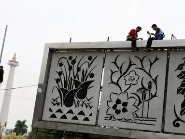 Pekerja memasang CCTV di Kawasan Monumen Nasional, Jakarta, Kamis (3/11). Pemasangan CCTV tersebut untuk meningkatkan keamanan di sekitar Monas. (Liputan6.com/Gempur M Surya)