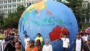 Replika bola dunia berukuran besar digelindingkan di sekitar kawasan Bundaran Hotel Indonesia, Jakarta, Minggu (16/9). Acara ini bagian dari peringatan Hari Ozon Sedunia yang jatuhnya setiap tanggal 16 September. (Liputan6.com/Helmi Fithriansyah)