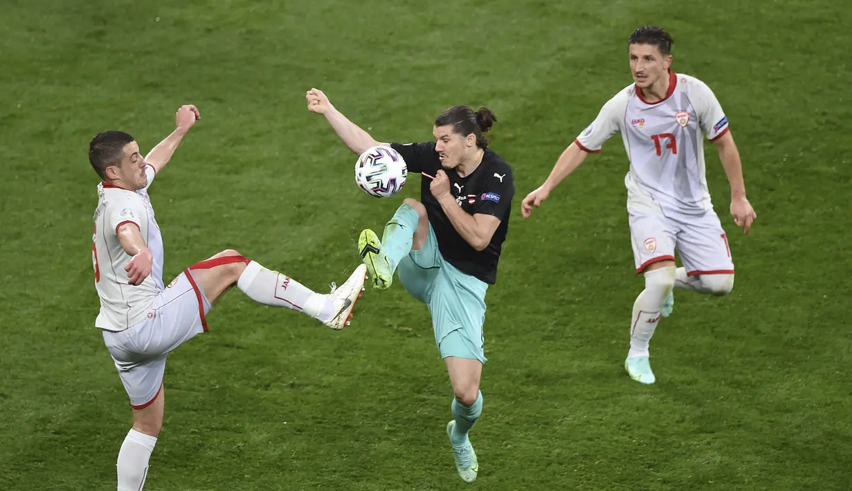Bek Makedonia Utara, Visar Musliu (kiri) berebut bola dengan gelandang Austria, Marcel Sabitzer pada pertandingan grup C Euro 2020 di stadion National Arena di Bucharest, Rumania, Minggu (13/6/2021). Austria menang atas Makedonia Utara dengan skor 3-1. (Mihai Barbu/Pool via AP)