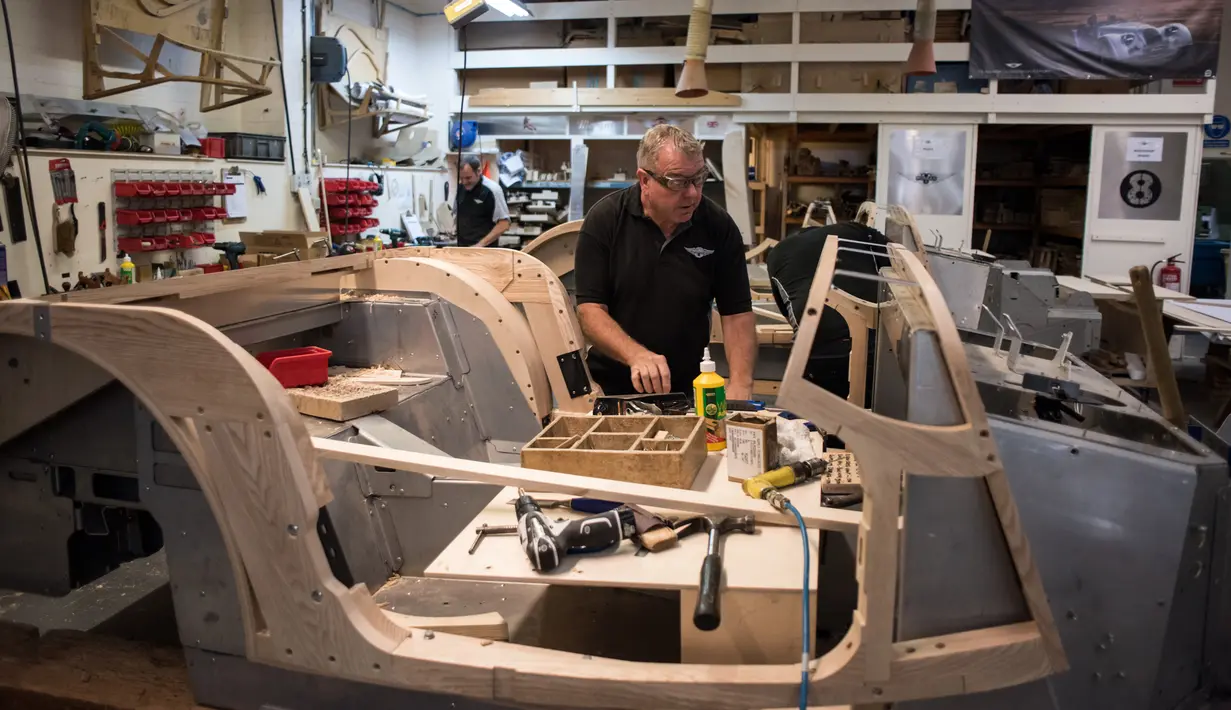Seorang pekerja menyelesaikan pembuatan mobil klasik dengan bahan dasar kayu ash di pabrik mobil Morgan Motor Company di Malvern, Birmingham, Inggris (13/8/2019). Morgan Motor Company telah memproduksi kendaraan klasik Inggris selama lebih dari 105 tahun. (AFP Photo/Oli Scarff)