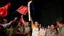Supermodel Adriana Lima bersorak sambil membawa obor pada malam penyambutan Olimpiade Rio 2016 di Maua Square Rio de Janeiro, Brasil, Kamis (4/8). (REUTERS / Pilar Olivares)