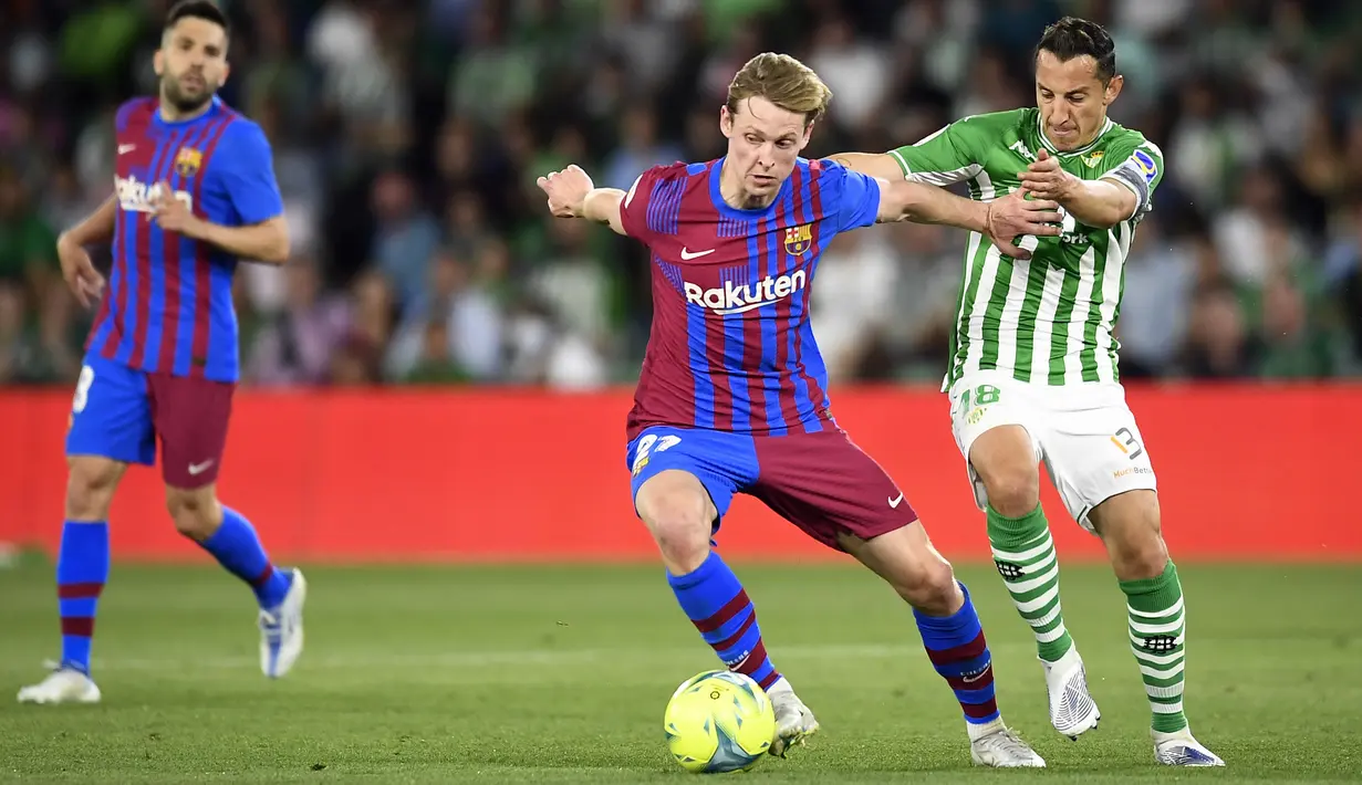 <p>Pemain Real Betis Andres Guardado (kanan) berebut bola dengan pemain Barcelona Frenkie de Jong pada pertandingan sepak bola La Liga Spanyol di Stadion Benito Villamarin, Seville, Spanyol, 7 Mei 2022. Barcelona menang 2-1. (AP Photo/Jose Breton)</p>