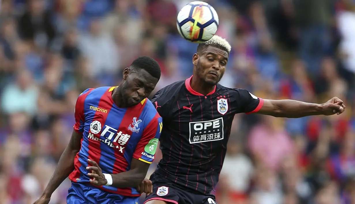 Huddersfield Town, Steve Mounie (kanan) berduel dengan pemain Crystal Palace pada laga perdana Premier League 2017-2018 di Selhurst Park, London, (12/8/2017). (Scott Heavey/PA via AP)