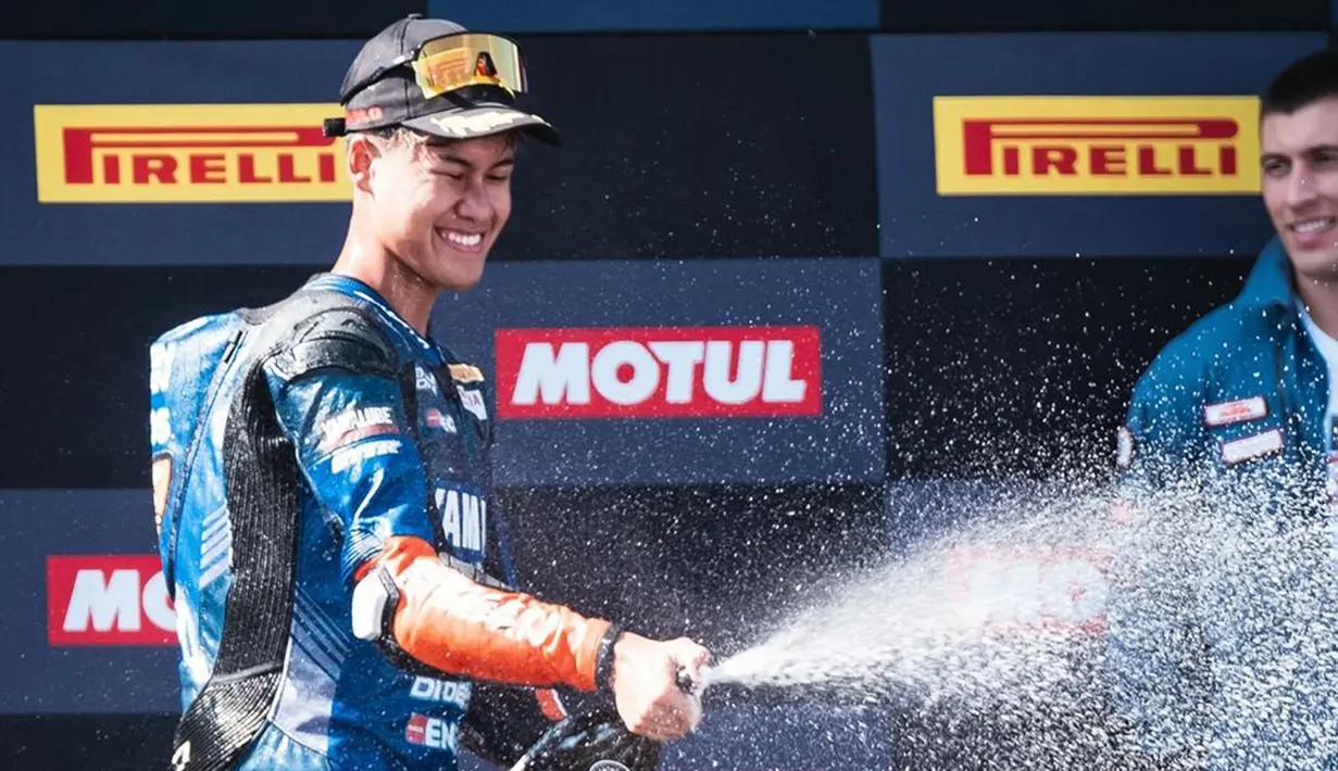 Aldi Satya Mahendra merayakannya dengan sebotol sampanye usai meraih gelar juara dunia WorldSSP300 2024 di Sirkuit Jerez, Minggu (20/10/2024) malam WIB. (Instagram Aldi Satya Mahendra)