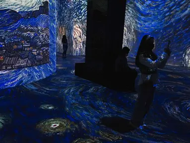 Seorang wanita mengambil foto di galeri seni digital Infinity des Lumieres di Dubai Mall, Dubai, Uni Emirat Arab, Senin (12/7/2021). Infinity des Lumieres menggunakan proyektor digital untuk memutar gambar bergerak karya seni di galeri besar. (AP Photo/Jon Gambrell)