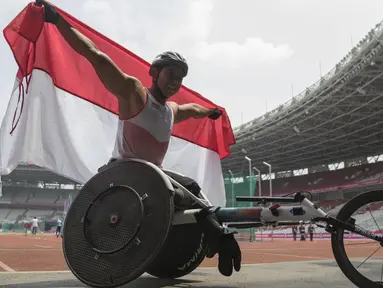 Pebalap kursi roda Indonesia, Jaenal Aripin, melakukan selebrasi usai meraih medali perak pada Asian Para Games cabang atletik nomor balap kursi roda 200 meter T 54 di SUGBK, Jakarta, Jumat (12/10). (Bola.com/Vitalis Yogi Trisna)