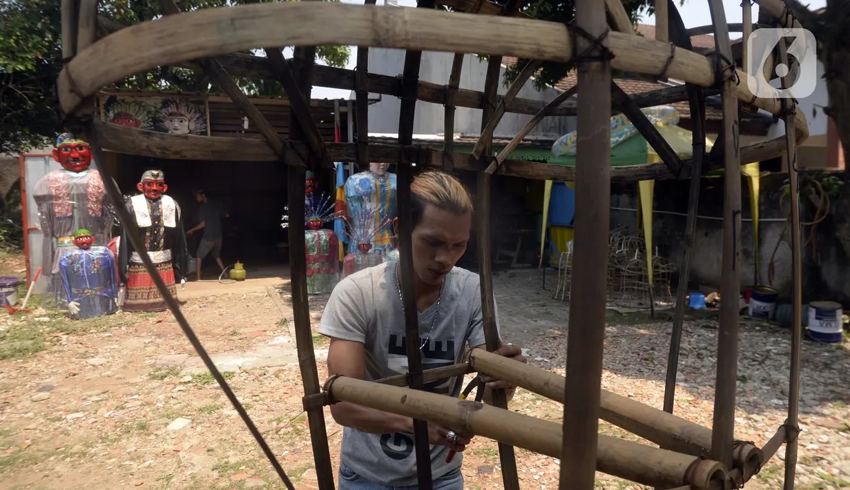 Perajin menyelesaikan pembuatan ondel-ondel di Kawasan Perkampungan Budaya Betawi, Setu Babakan, Jagakarsa, Jakarta Selatan, Selasa (28/7/2020). Selama pandemi COVID-19, perajin mengaku sepi pemesanan ondel-ondel kendati harus terus memproduksi untuk stok ke depan. (merdeka.com/Dwi Narwoko)