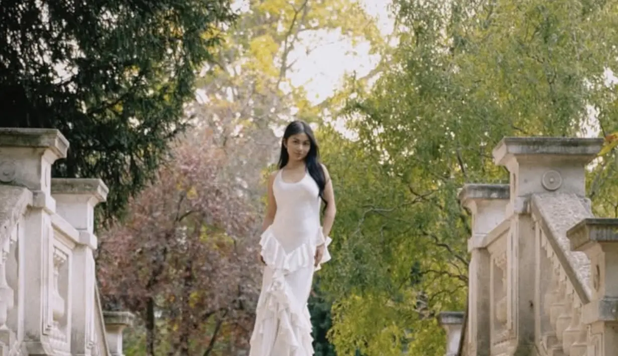 Berlatar di Parc Monceau, taman ikonik di Paris yang dikenal dengan arsitektur klasiknya, Ariel tampil anggun dalam balutan gaun putih yang memikat. [@npmalina]