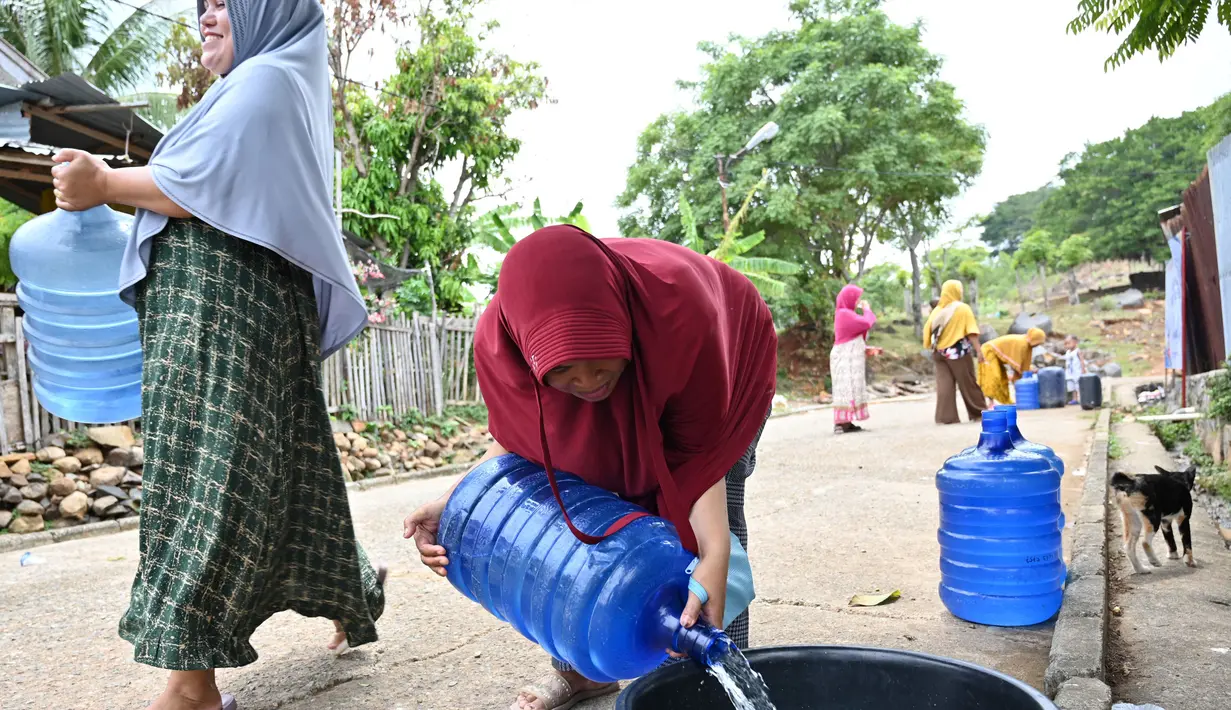 Warga yang menempati pemukiman di dataran tinggi Aceh setelah bencana tsunami 2004 mendapat distribusi air dari kepolisian setempat di Neuheun, Aceh Besar, 4 Oktober 2023. (Chaideer Mahyuddin/AFP)
