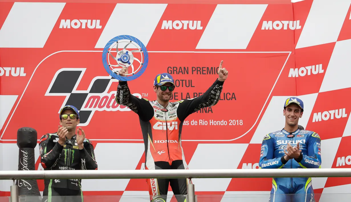 Pembalap LCR Honda, Cal Crutchlow merayakan kemenangannya pada balapan MotoGP Argentina di samping Johann Zarco dari Yamaha Tech 3 dan Alex Rins dari ESP Suzuki Ecstar di atas podium Sirkuit Termas de Rio Hondo, Minggu (8/4). (AP/Natacha Pisarenko)