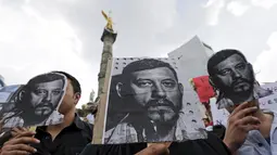 Sejumlah Wartawan dan aktivis membawa foto Ruben Espinosa saat menggelar protes di monumen Kemerdekaan, Meksiko, Minggu (2/8/2015).   Ia ditemukan dengan dua luka tembak bersama empat perempuan lainnya. (REUTERS/Henry Romero)