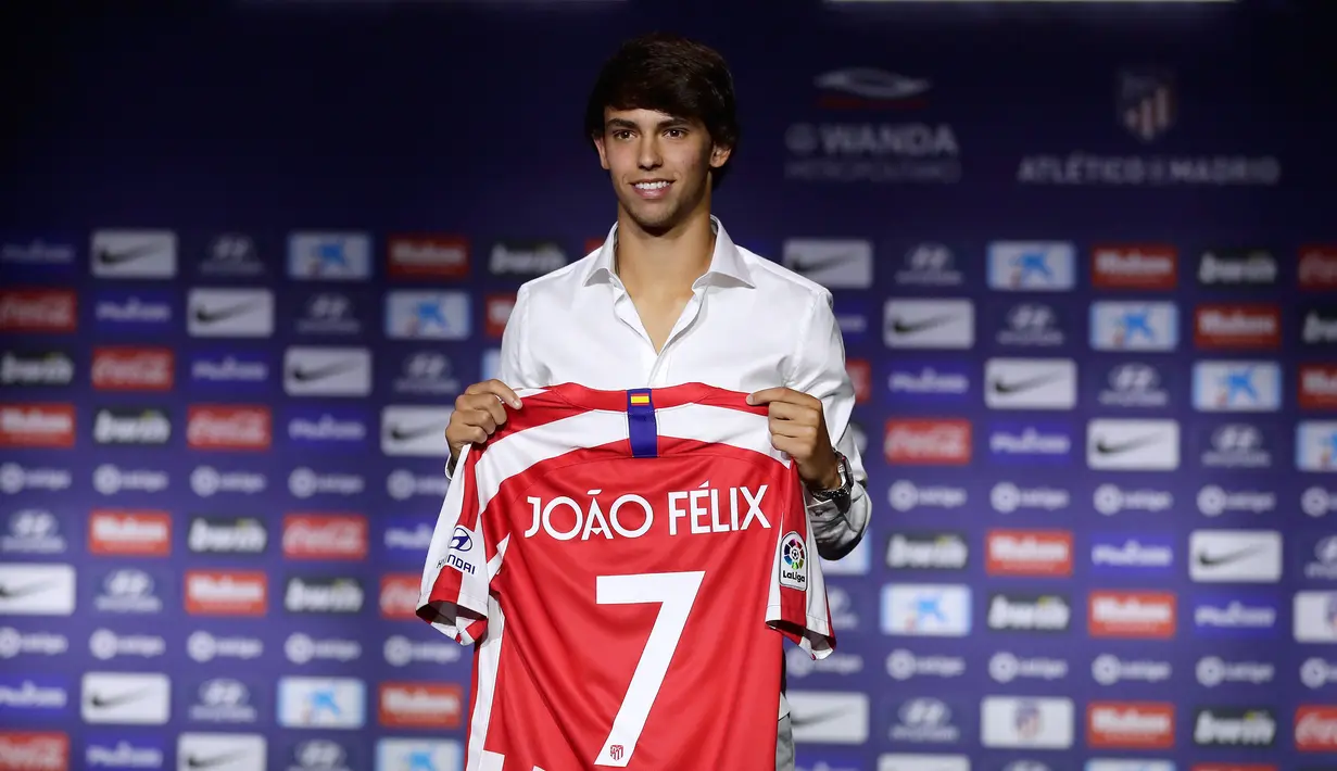 Gelandang Atletico Madrid, Joao Felix tersenyum saat berpose dengan jersey klub barunya selama perkenalan dirinya di Stadion Wanda Metropolitano, Madrid (8/7/2019). Pemain Portugal ini resmi diboyong Atletico seharga 126 juta euro dengan kontrak selama tujuh tahun. (AP Photo/Manu Fernandez)