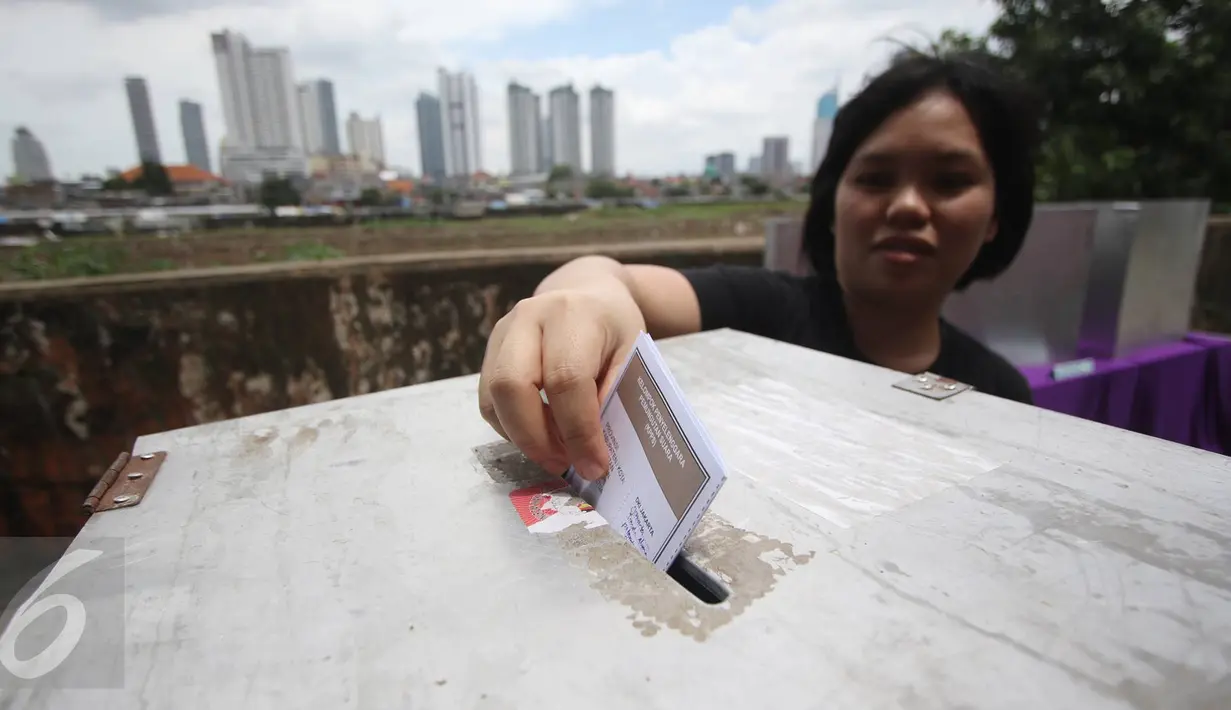 Warga memasukkan surat suara di TPS 023 Petamburan, Jakarta, Rabu (15/2). Di kawasan itu, petugas melakukan jemput suara kepada warga lansia yang tidak sanggup berjalan menuju TPS (Liputan6.com/Immanuel Antonius)