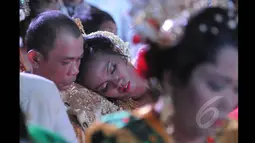 Seorang pengantin tampak terlelap saat menunggu giliran prosesi pernikahan massal di Istora Senayan, Jakarta, Rabu (28/1/2015). (Liputan6.com/Herman Zakharia)