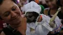 Seorang wanita membawa anjingnya yang didandani dan dihias untuk mengikuti misa San Lazaro di Monimbo, Masaya, Nikaragua (18/3). (AFP/Inti Ocon)