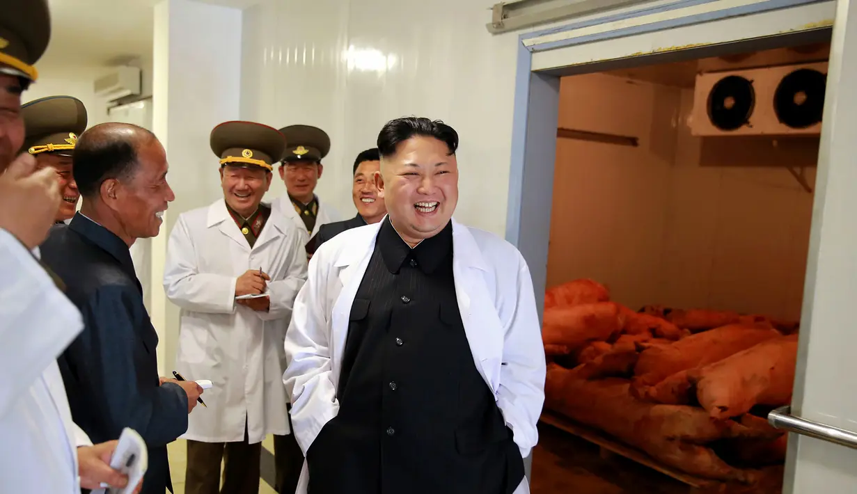 Pemimpin Korea Utara Kim Jong Un berbincang dengan para pejabat saat mengunjungi Peternakan Babi Thaechon di Korea Utara, 23 April 2017. (AFP /Foto/KCNA VIA KNS/Str)