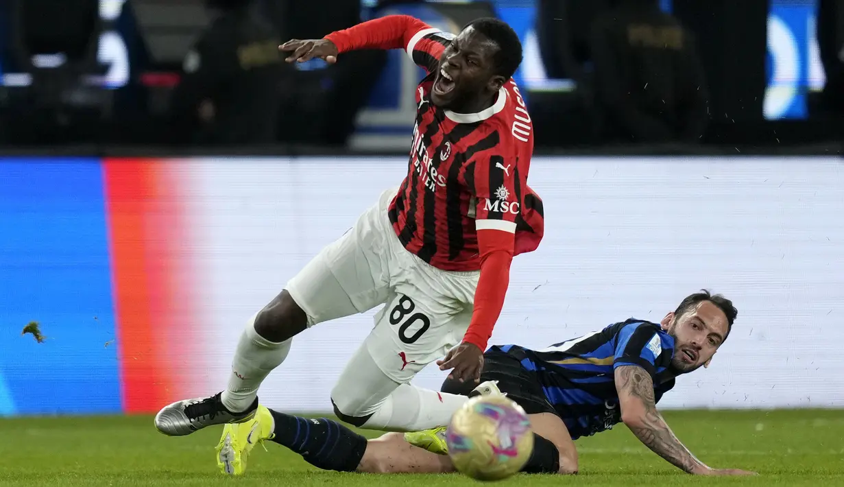Pemain AC Milan, Yunus Musah (kiri) berebut bola dengan pemain Inter Milan, Hakan Calhanoglu pada laga final Piala Super Italia 2024/2025 yang berlangsung di Al-Awwal Park, Riyadh, Arab Saudi, Senin (06/01/2025) waktu setempat. (AP Photo/Altaf Qadri)