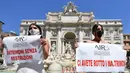 Pengantin perempuan yang mengenakan gaun pernikahan mereka melakukan protes dengan flashmob di Trevi Fountain, Roma, Selasa (7/7/2020). Mereka memprotes kebijakan pemerintah Italia yang masih melarang adanya acara pernikahan, meski penerapan lockdown sudah dilonggarkan. (Tiziana FABI/AFP)