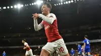 Gelandang Arsenal, Mesut Ozil, merayakan gol yang dicetaknya ke gawang Leicester pada laga Premier League Inggris di Stadion Emirates, London, Senin (22/10). Arsenal menang 3-1 atas Leicester. (AFP/Glyn Kirk)