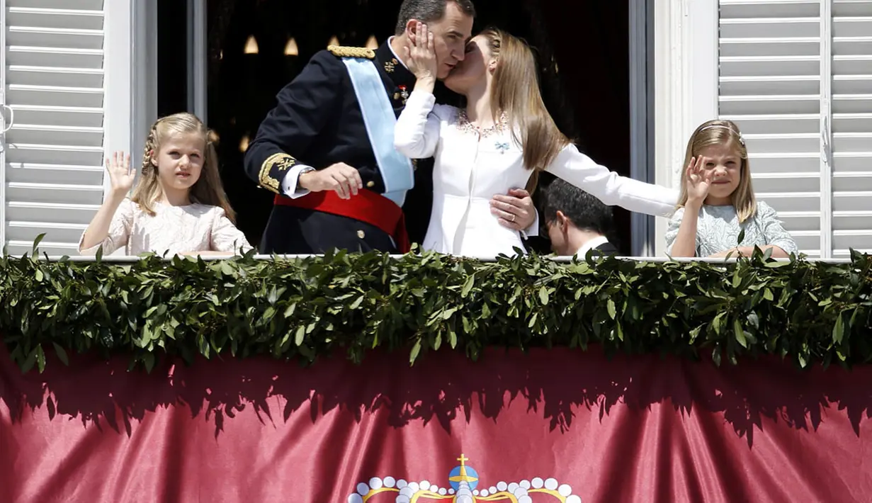 Ratu Letizia (kedua dari kanan) mencium Raja Spanyol, Felipe VI saat muncul kali pertama di balkon istana kerajaan di Madrid, (19/6/2014). (REUTERS/Andrea Comas)