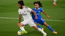 Gelandang Real Madrid, Isco, berebut bola dengan bek Getafe, Marc Cucurella, pada laga lanjutan La Liga pekan ke-33 di Stadion Alfredo Di Stefano, Jumat (3/7/2020) dini hari WIB. Real Madrid menang 1-0 atas Getafe. (AFP/Gabriel Bouys)