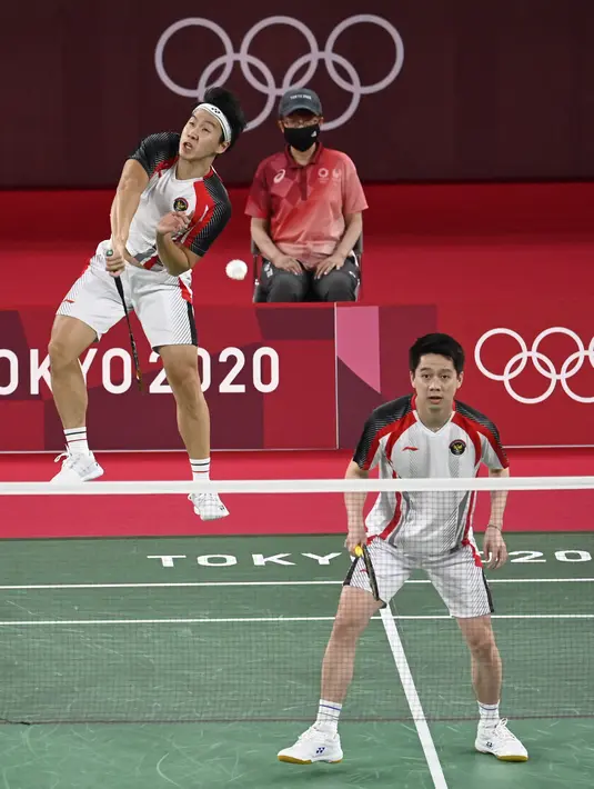 Ganda putra Indonesia Kevin Sanjaya/Marcus Gideon saat melawan pasangan India Chirag Shetty/Satwiksairaj Rankireddy pada cabang bulu tangkis Olimpiade Tokyo 2020 di Musashino Forest Sports Plaza, Tokyo, Senin (26/7/2021). Kevin/Marcus menang 21-13 dan 21-12. (AFP/Alexander Nemenov)