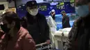 Seorang wanita mengenakan jas hujan dan masker berada di sebuah supermarket di Wuhan, provinsi Hubei, China, Senin, (10/2/2020). Angka kematian akibat virus corona di China meningkat lagi, dengan kematian hari Senin (10/2/2020) mencapai 908 orang, dengan adanya 97 kematian baru. (Chinatopix via AP)