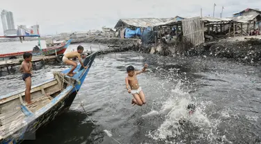 Anak-anak bermain air di kawasan pantai penuh sampah yang terbawa arus di Muara Angke, Jakarta, Rabu (10/2). Genangan sampah yang terbawa arus oleh angin musim barat ini tak menyurutkan anak-anak untuk bermain air. (Liputan6.com/Faizal Fanani)