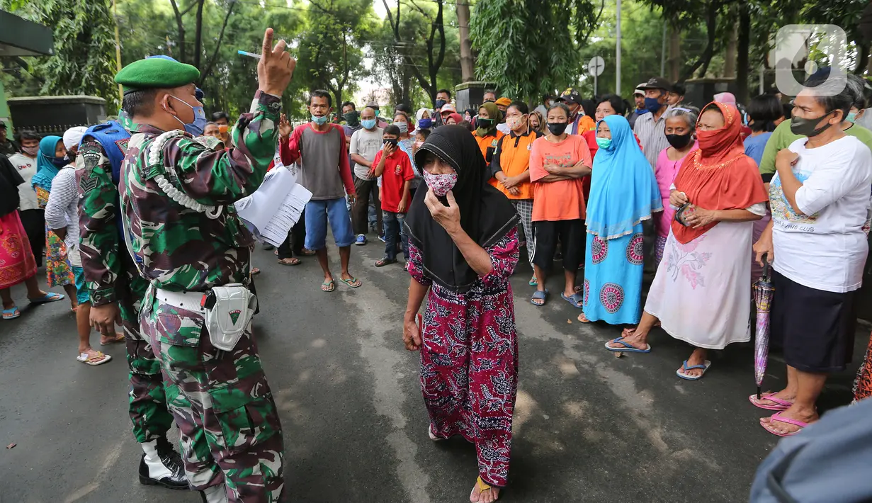 Warga antre menunggu panggilan untuk mendapatkan bantuan beras di Makodim 0506 Tangerang, Banten, Senin (27/4/2020). Program bantuan 1,5 kg beras per orang melalui ATM Pertanian Si Komandan menyasar kepada masyarakat yang membutuhkan akibat dampak pandemi Covid-19. (Liputan6.com/Fery Pradolo)
