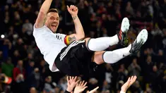 Penyerang Jerman, Lukas Podolski melakukan selebrasi bersama setelah pertandingan persahabatan antara Jerman dan Inggris di Dortmund, (23/3). Pertandingan ini merupakan laga terakhir Podolski bersama tim nasional Jerman. (AP/Martin Meissner)