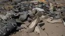 Sepatu bekas tergeletak di tengah tumpukan besar pakaian bekas yang menutupi gurun pasir di dekat lingkungan La Mula di Alto Hospicio, Chile, Senin (13/12/2021). Chile adalah importir besar pakaian bekas, dan barang-barang yang tidak terjual dibuang di sini. (AP Photo/Matias Delacroix)