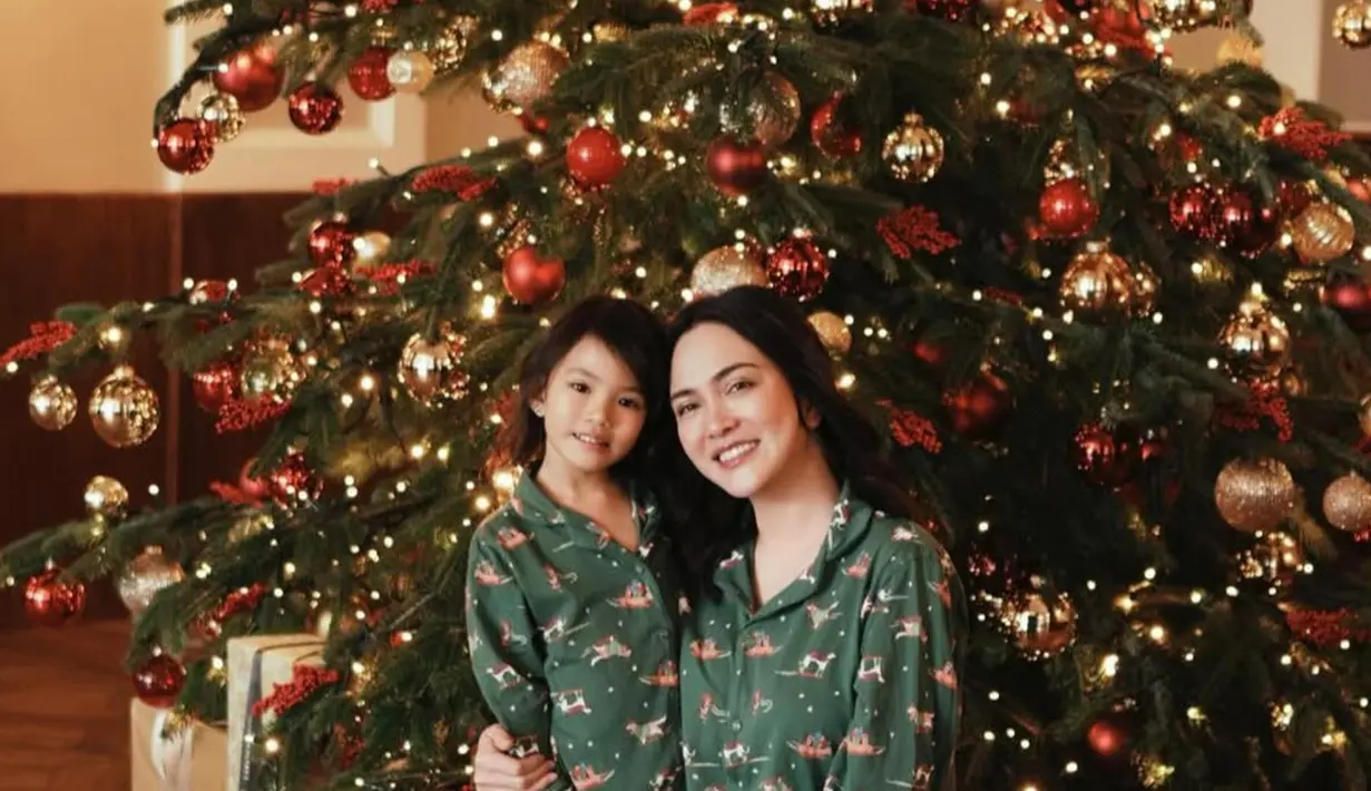 Shandy Aulia dan putrinya merayakan Natal dengan outfit kompak berfoto di depan pohon Natal besar. Keduanya mengenakan piyama hijau. [@shandyaulia]