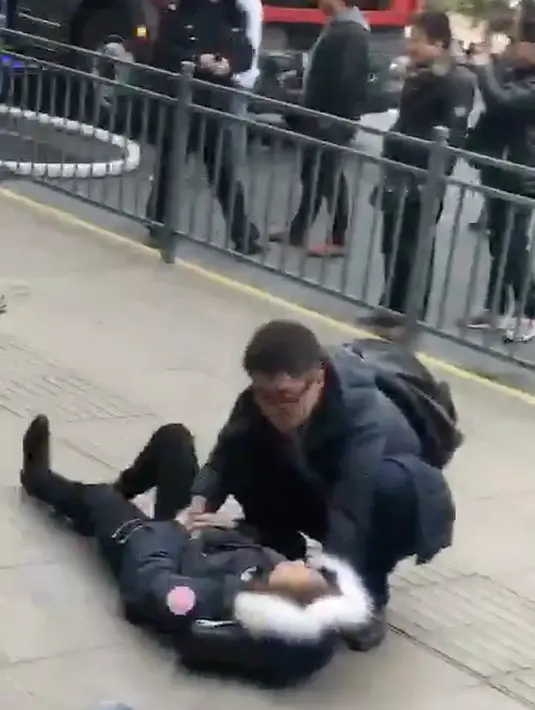 Seorang pria membantu pejalan kaki yang cedera ditabrak sebuah van di trotoar daerah sibuk di Shanghai, China, Jumat (2/2). Belum ada pernyataan dari kepolisian mengenai apakah insiden itu disengaja atau murni kecelakaan. (AP Photo)