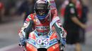 Pembalap Ducati Andrea Dovizioso mengendarai motornya sambil membawa bendera usai memenangkan balapan MotoGP Qatar 2018 di Sirkuit Internasional Losail (18/3). Andrea Dovizioso sukses memenangi seri pembuka MotoGP 2018 di Qatar. (AFP Photo/Karim Jaafar)