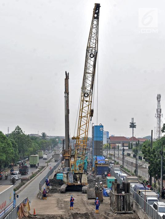 Pekerja menggunakan alat berat saat pembangunan proyek enam ruas tol dalam kota seksi 1A di kawasan Cakung, Jakarta, Senin (5/11). Proyek enam ruas tol dalam kota memiliki panjang mencapai 69,77 Km. (Liputan6.com/Iqbal Nugroho)