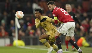 Gelandang Manchester United, Bruno Fernandes berebut bola dengan pemain Barcelona, Alejandro Balde selama pertandingan leg kedua playoff Liga Europa stadion Old Trafford di Manchester, Inggris, Jumat (24/2/2023). Hasil ini membuat MU lolos dengan agregat kemenangan 4-3 atas Barcelona. (AP Photo/Dave Thompson)